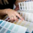 Close-up of two women choosing samples of wall paint. Interior designer consulting a client looking at a color swatch